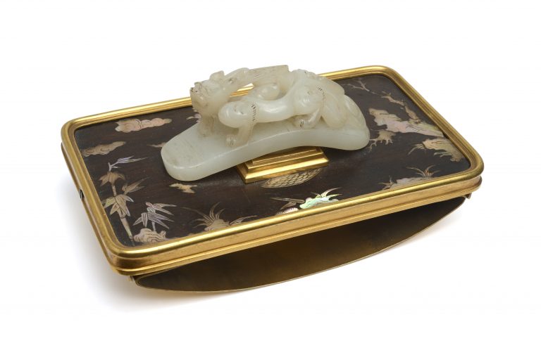 BOIN-TABURET, EPOQUE XIXÈME SIÈCLE Buvard composé de laque du Japon (XVIIIème siècle), d’une fibule en Jade blanc « Chieng Lung » (1736-1796) et d’une monture en bronze doré (XIXème siècle). Dimensions pour le buvard sans la fibule : 15,5x9,2x4,1 cm Dimension de la fibule seule : 9x3x3,7 cm